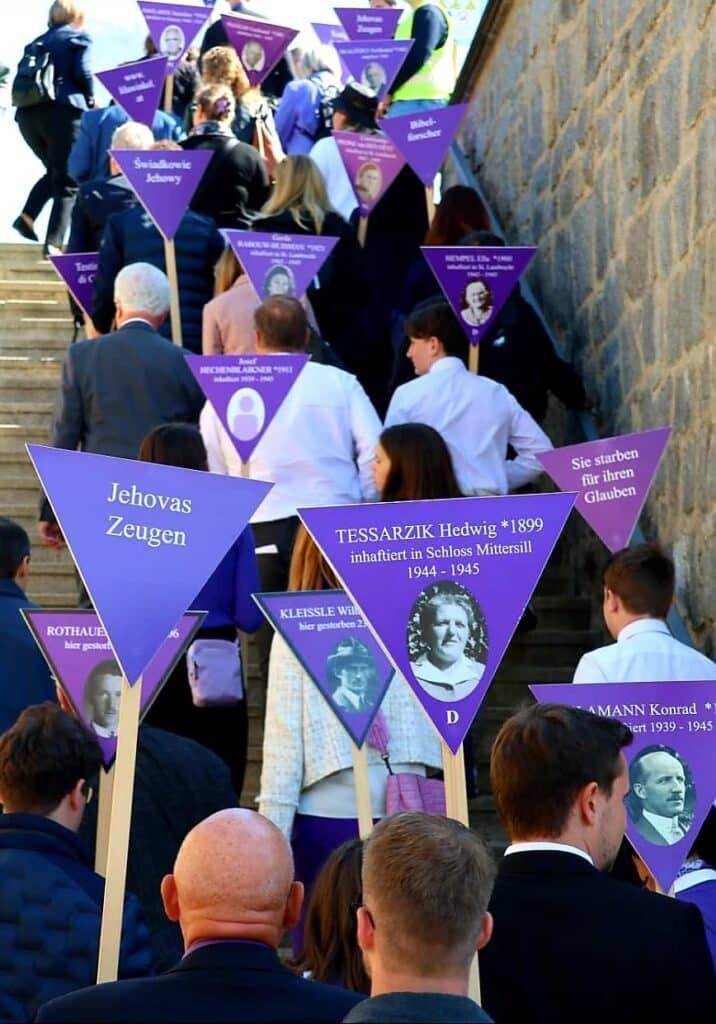 Teilnehmer an der Gedenkfeier "Niemals wieder!" zum 80. Jahrestages der Befreiung des KZ Mauthausen gehen eine Treppe hoch.