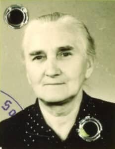 Schwarz-Weiß-Porträtfoto von Martha Gehrke aus dem Jahr 1952. Zu sehen ist eine ältere Frau mit zurückgekämmtem, hellem Haar und ernstem, ruhigem Gesichtsausdruck. Sie trägt eine dunkle Bluse mit hellen Punkten. Auf dem Foto sind Lochungen und ein runder Stempelabdruck erkennbar, die darauf hindeuten, dass es sich um eine Aufnahme aus einem amtlichen Dokument handelt.